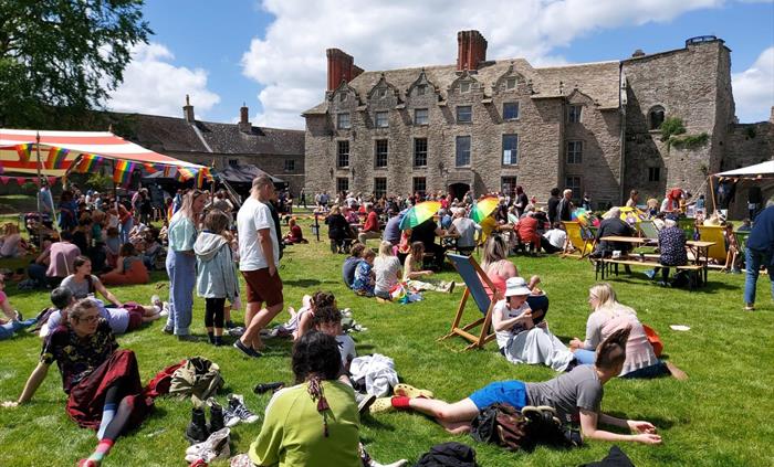 The photo shows visitors enjoying the lawns at Hay Castle during the Hay Pride event June 2022